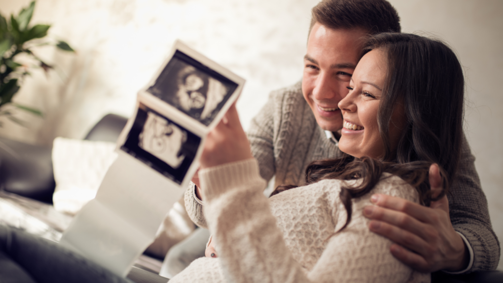 couple joyfully looking at a sonogram
